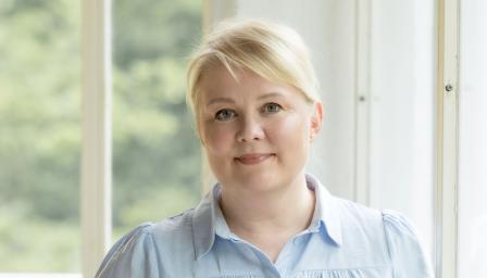 Kuvassa kouluttaja Sirpa Karvonen ikkunan edessä.