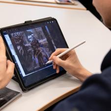 Taidepajan opiskelija digimaalaa tabletilla.