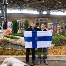 Kaksi nuorta pitää käsissään Suomen lippua.