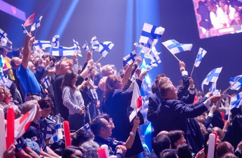 Suomen lippuja heilutetaan katsomossa.