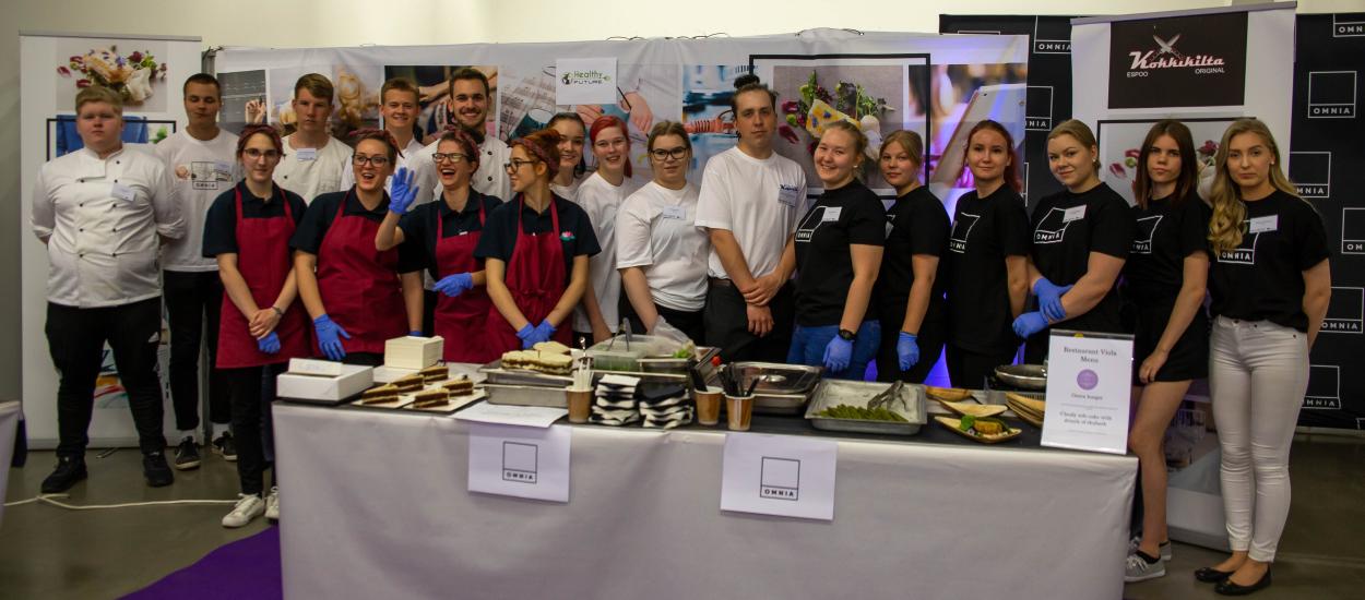 Students of the Omnia Healthy Future project line up at the table.